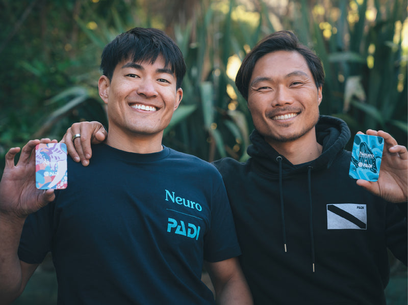 Neuro co-founders holding Neuro Energy & Focus Mints sachets outdoors